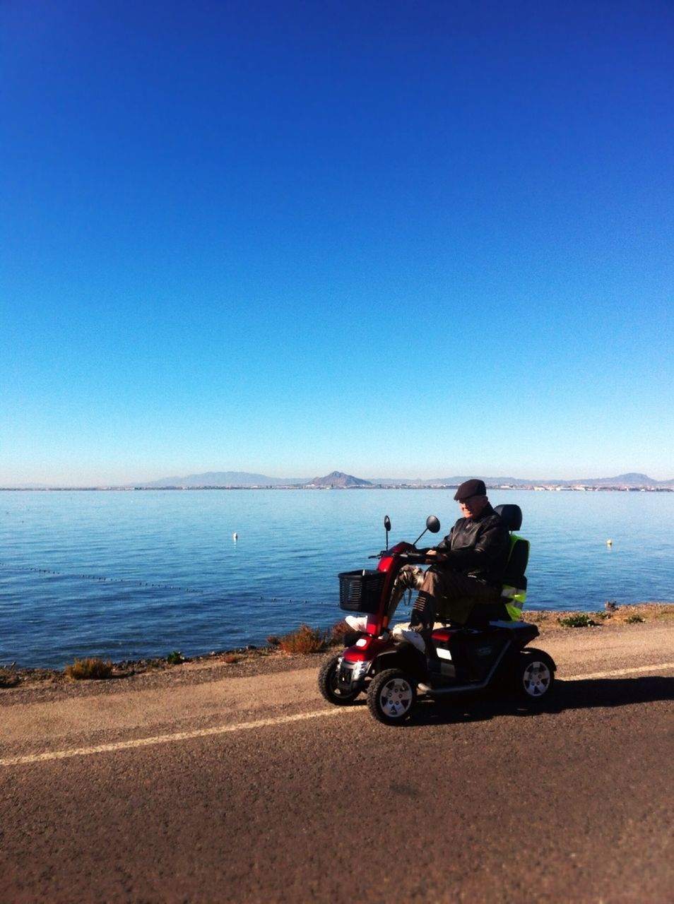 transportation, mode of transport, bicycle, land vehicle, clear sky, lifestyles, leisure activity, sea, men, copy space, beach, water, horizon over water, riding, blue, motorcycle, travel, nature