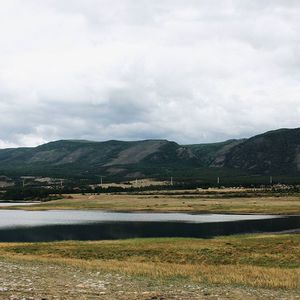 Scenic view of mountains against cloudy sky