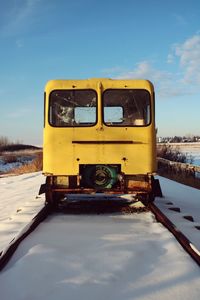 Yellow car against sky during winter