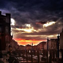 Buildings against cloudy sky at sunset