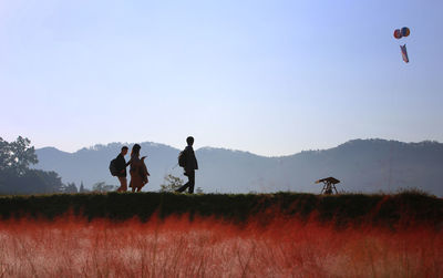 Men on field against clear sky