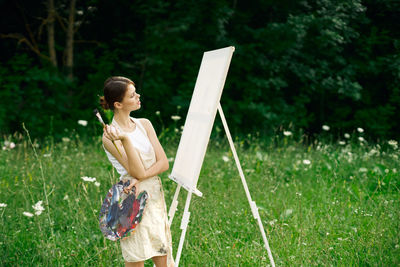 Full length of woman holding umbrella on field