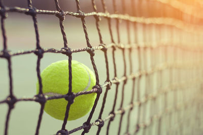 Close-up of tennis ball hitting net