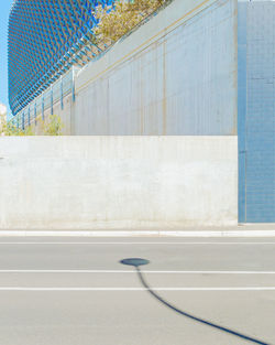 Empty road by wall in city