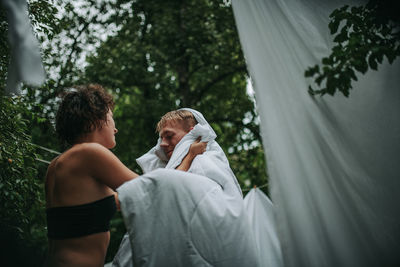 Rear view of couple kissing against trees