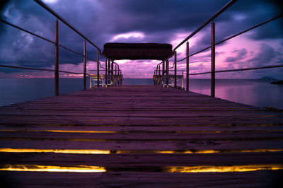 Pier over sea against sky at sunset