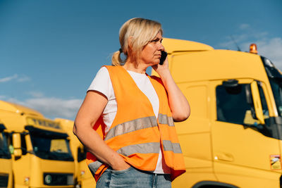 Side view of mechanic talking on smart phone