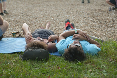 Rear view of couple sitting on grassy field