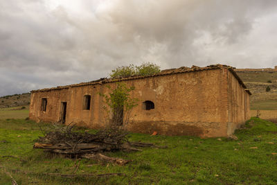 Old ruin building on field against sky