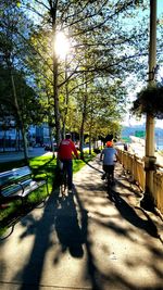 Rear view of people walking on footpath