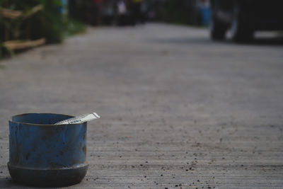 Paper currency in garbage bin on footpath