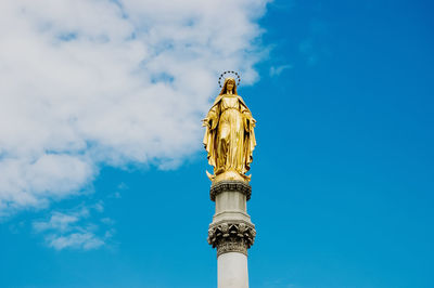 Low angle view of statue against blue sky