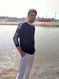 Portrait of young man standing on beach