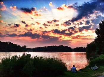 Scenic view of calm lake against sunset