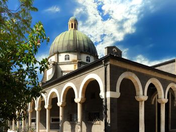 Low angle view of church by building against sky