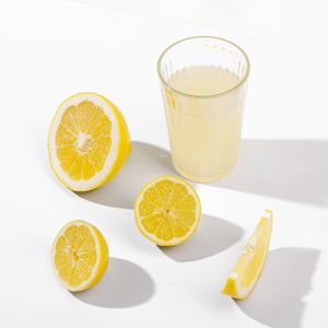 Close-up of lemon slices in glass against white background