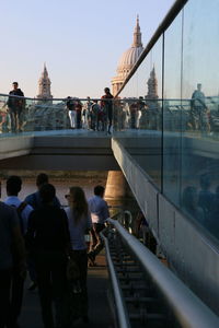 People at observation point of city against sky