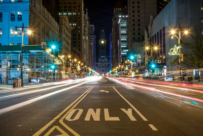 Light trails on road in city at night