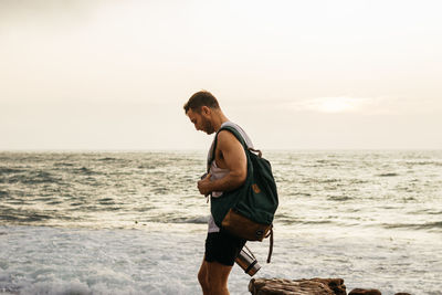 Rear view of man on beach against sky