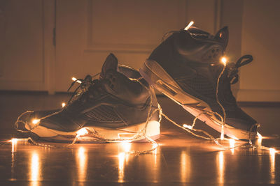 Shoes with illuminated string lights on floor at home