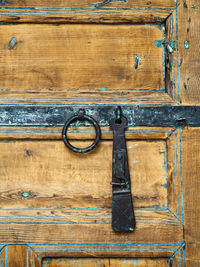 Metallic latch and door knocker on old wooden door