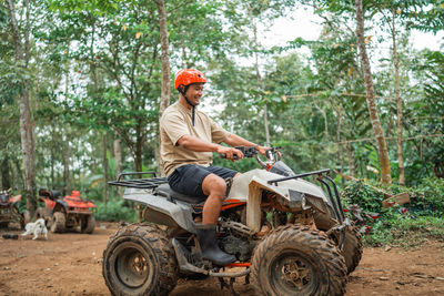 Side view of man sitting on field