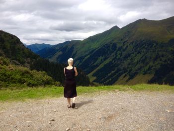 Full length of woman standing on mountain landscape