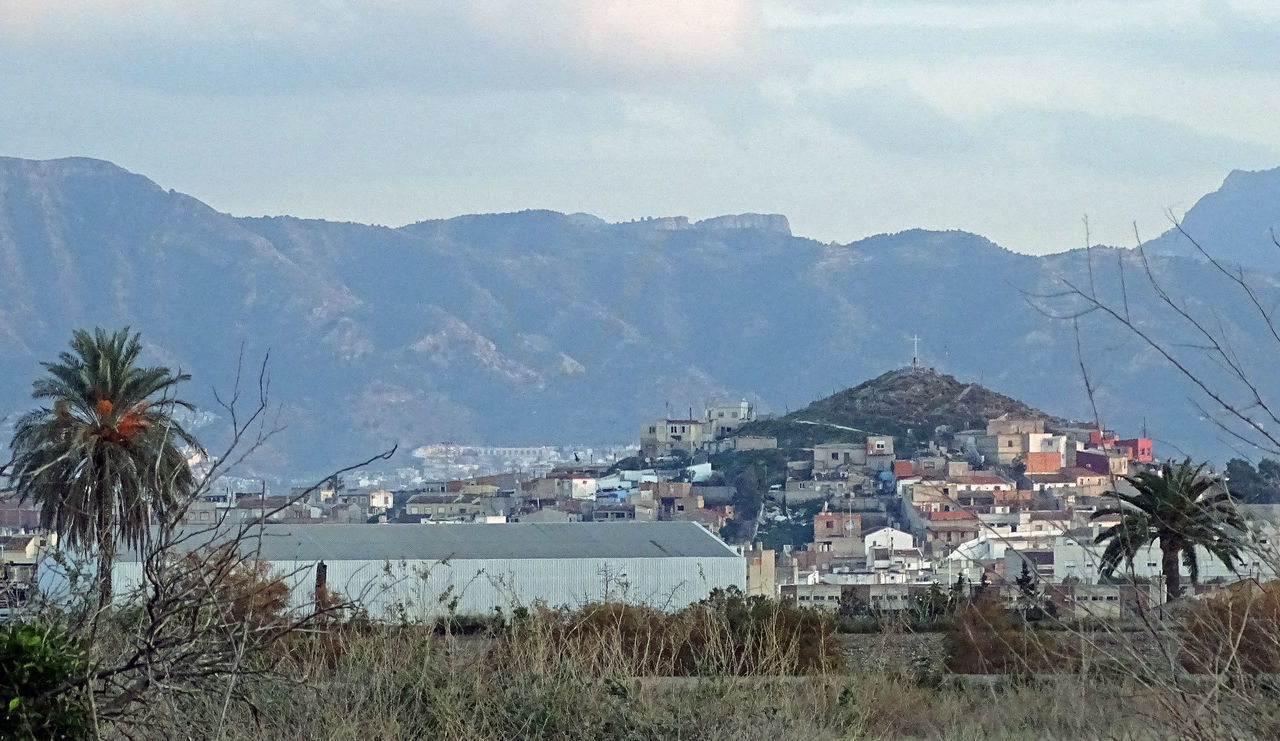 TOWNSCAPE BY MOUNTAIN AGAINST SKY