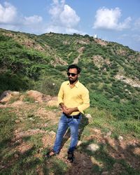 Young man wearing sunglasses standing on mountain