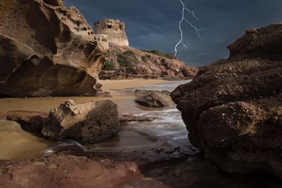 Rocks in sea against sky