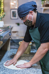 Midsection of man working in kitchen