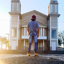 Full length rear view of man standing against building