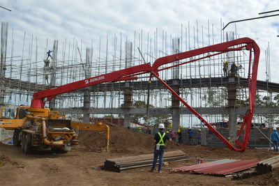 Man working at construction site in city against sky