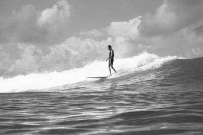 Man surfing in sea against sky