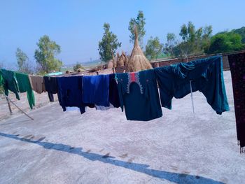 Clothes drying on clothesline against blue sky