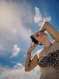 Low angle view of woman standing against sky