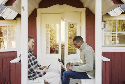 Couple sitting in front of wooden house