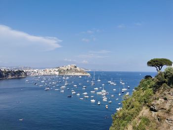 High angle view of townscape by sea against blue sky