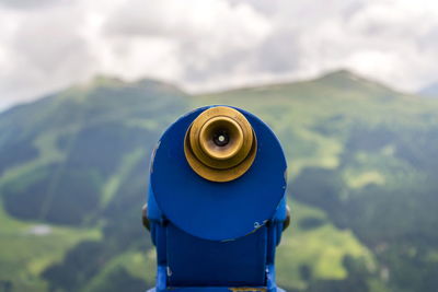 Close-up of coin-operated binoculars against sky