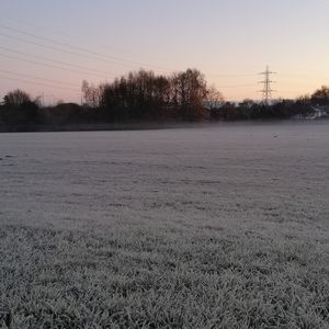 Scenic view of field against clear sky during winter