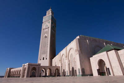 Low angle view of mosque hassan ii against blue sky