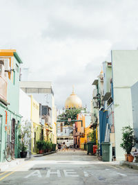 Street amidst buildings against sky in city