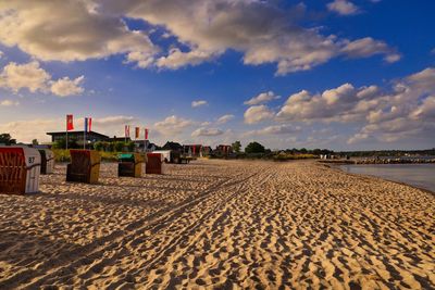 Scenic view of beach by buildings against sky