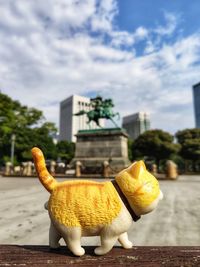 Close-up of stuffed toy in city against sky