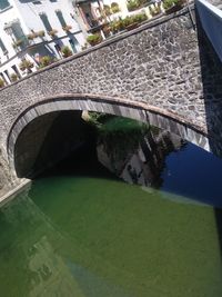 High angle view of arch bridge over canal by buildings