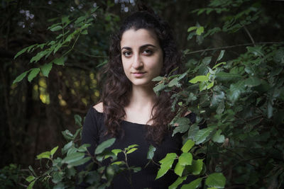 Portrait of young woman against plants