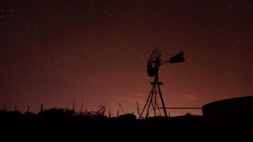 Low angle view of silhouette windmill against sky at night