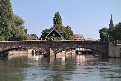 Arch bridge over river against sky