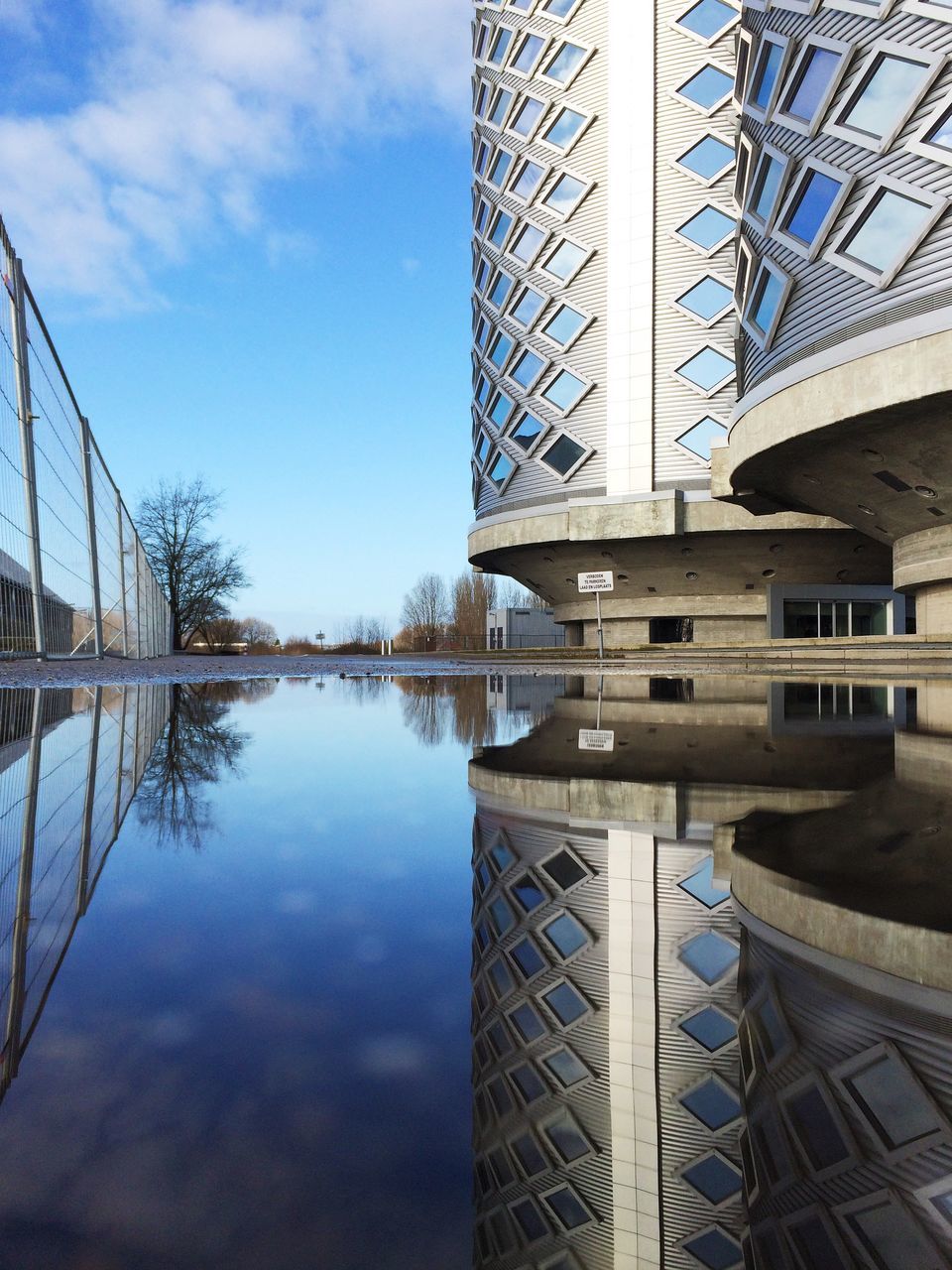 architecture, built structure, reflection, building exterior, water, sky, city, modern, bridge - man made structure, connection, low angle view, cloud - sky, building, river, outdoors, waterfront, day, no people, tower, blue