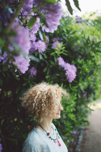 Woman standing against purple flowering plants